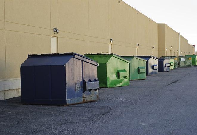 a series of colorful, utilitarian dumpsters deployed in a construction site in Costa Mesa